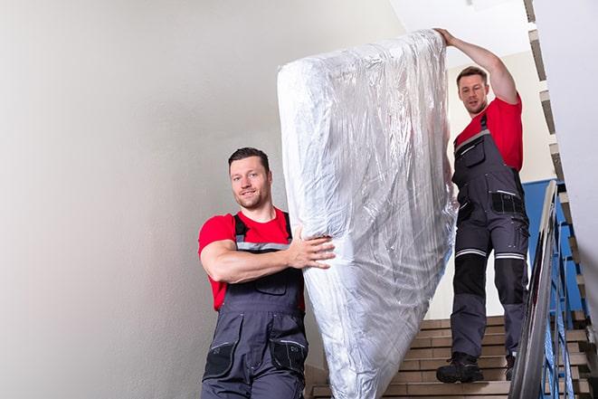 two people disposing of box spring from bedroom in Stagecoach